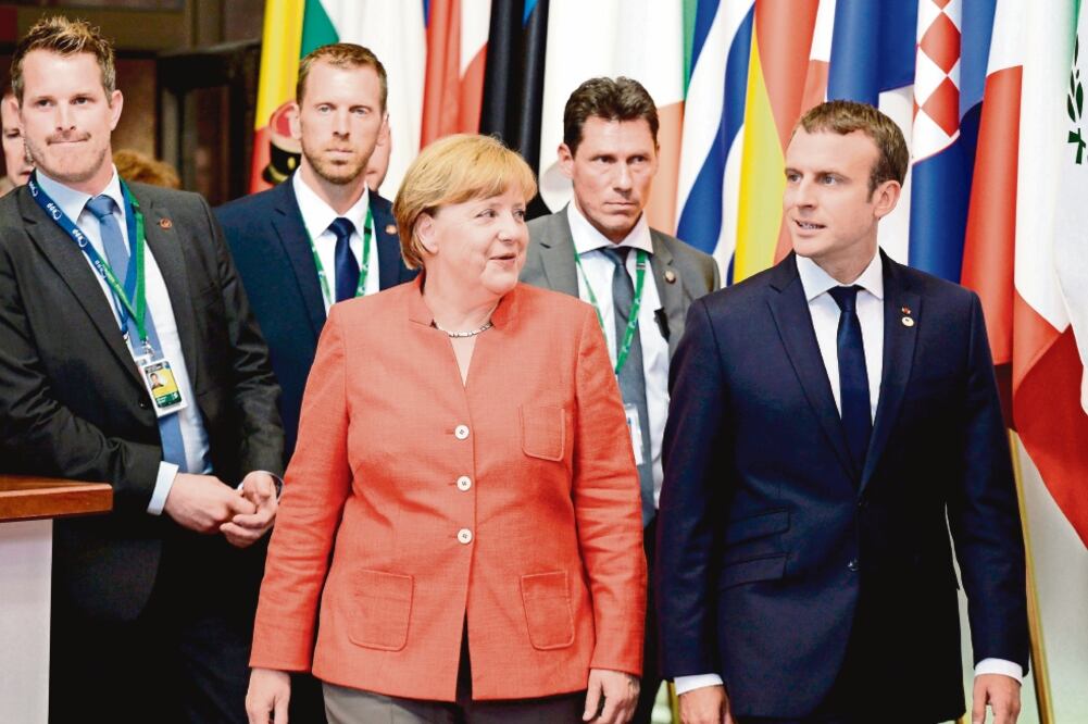 La canciller alemana, Angela Merkel, y el presidente de Francia, Emmanuel Macron, dialogaron ayer tras la reunión de la Unión Europea en Bruselas. (THIERRY CHARLIER. AFP)