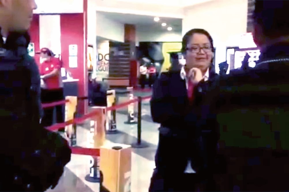 Mientras unos policías la custodian, #LadyCinemex expresa que la niña, que vende mazapanes, “sólo va a aventar sus porquerías” al complejo. (TOMADA DE VIDEO)