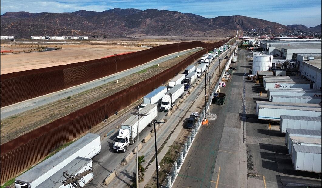 Vehículos de carga hacen una larga fila para cruzar una garita hacia EU, el pasado miércoles 5 de marzo de 2025 en la ciudad de Tijuana, México, tras la entrada en vigor de los aranceles del 25% impuestos por el presidente estadounidense, Donald Trump. Foto: EFE