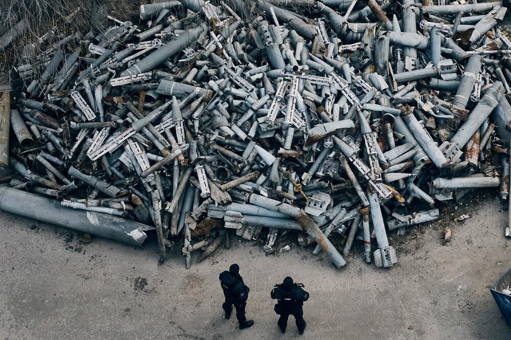 Policías revisan fragmentos de cohetes rusos, incluyendo bases de bombas de racimo, que impactaron en Kharkiv, Ucrania, en diciembre pasado. AP