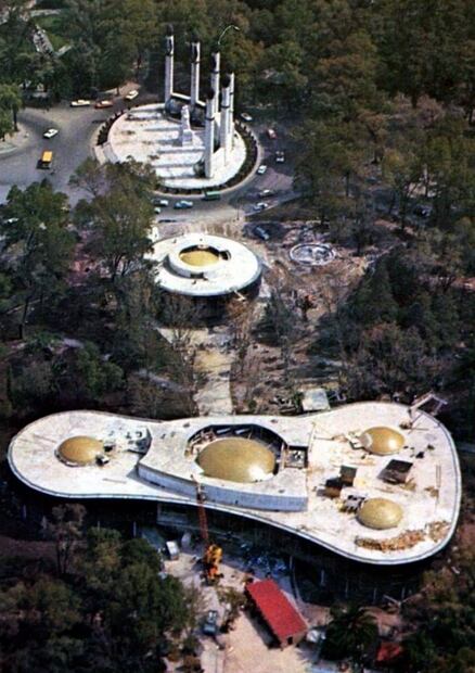 Toma aérea del Museo de Arte Moderno antes de su apertura, en 1964. Este museo se compone de dos cuerpos ambos albergan exposiciones permanentes y temporales; sus formas circulares invitan al constante movimiento, que hacen juego con las exhibiciones. Al fondo se alcanza a ver el monumento a los Niños Héroes de Chapultepec. Colección Carlos Villasana.