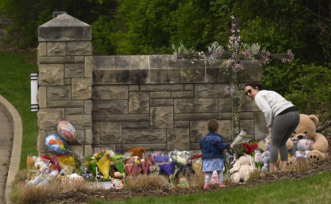 Una mujer y un niño llevan flores a la entrada de la Escuela Covenant, que se ha convertido en un monumento a las víctimas de los disparos. Foto: AP