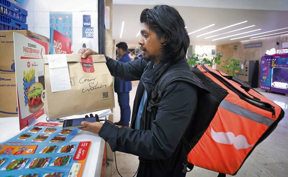 Luego de recoger un pedido el mensajero corre para cumplir con la entrega, de ello depende que su jornada laboral sea más productiva. Foto: Gabriel Pano / EL UNIVERSAL