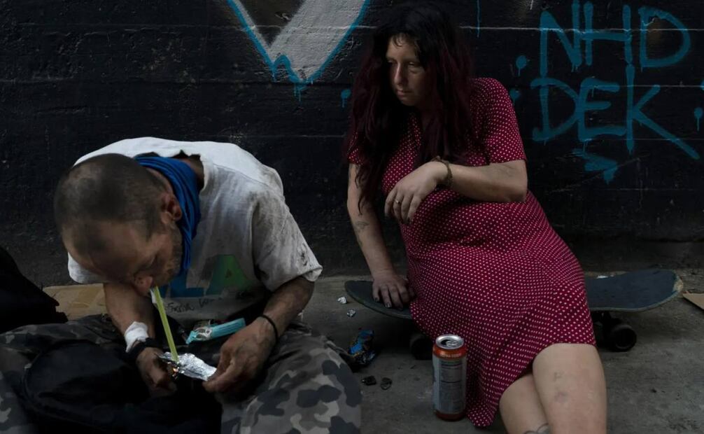 Jenn Bennett, que está drogada con fentanilo, se sienta sobre su patineta con un ojo morado mientras su amigo, Jesse Williams, fuma la droga el martes 9 de agosto de 2022, en Los Ángeles. El uso de este poderoso opioide sintético, el cual es barato de producir y con frecuencia es vendido solo o entremezclado con otras drogas, ha aumentado exponencialmente. Como es 50 veces más potente que la heroína, incluso una dosis pequeña puede ser letal. Rápidamente se ha convertido en la droga más mortífera en Estados Unidos, según la agencia antinarcóticos DEA. Dos terceras partes de las 107.000 muertes por sobredosis en 2021 fueron atribuidas a opioides sintéticos como el fentanilo, indicaron los Centros para el Control y la Prevención de Enfermedades. Foto: AP