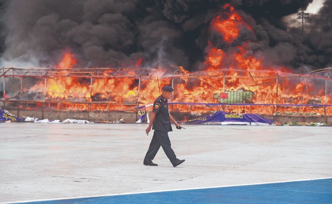 Un bombero, junto a una pila de drogas ilegales en llamas durante el Día Internacional contra el Abuso y el Tráfico Ilícito de Drogas, en Yangón, Myanmar. Foto: de NYEIN CHAN NAING. EFE