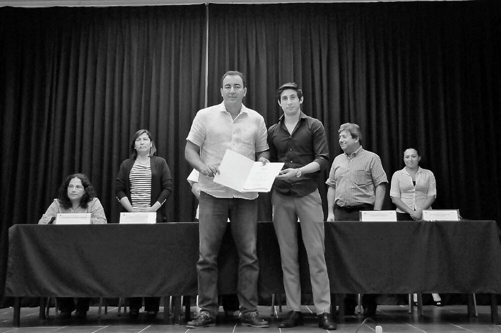 El titular de la Secretaría de Educación y Cultura de Quintana Roo (SEyC), José Alberto Alonso Ovando, entrega su reconocimiento a Jordan Polanco. (Foto: ADRIANA VARILLAS. EL UNIVERSAL)