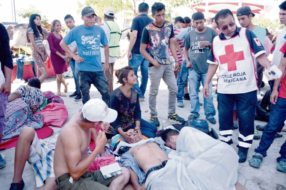 Personal de la Cruz Roja Mexicana atendió a los hondureños que presentaban alguna enfermedad, en Huixtla. (JOHAN ORDOÑEZ. AFP)