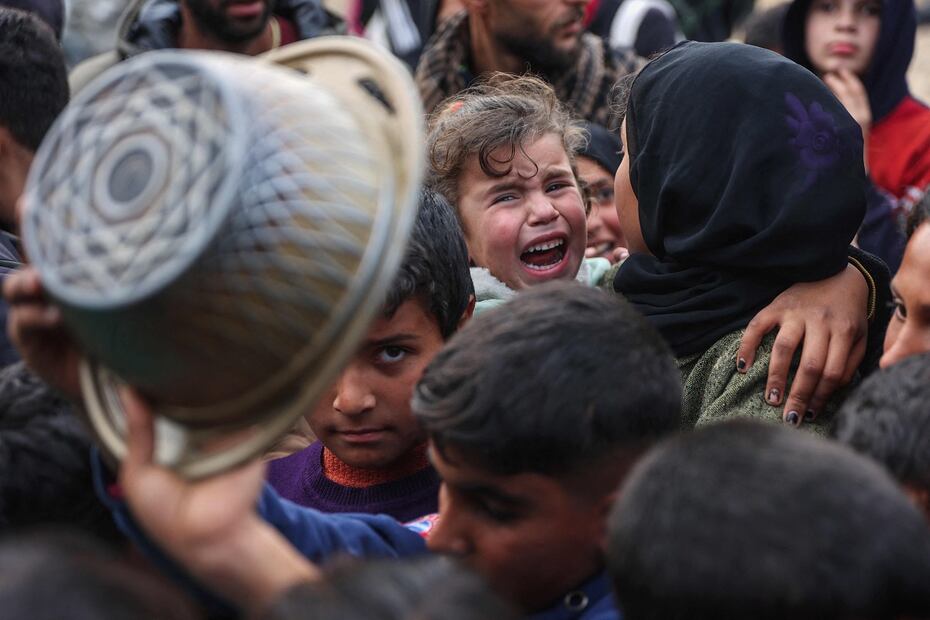 Desplazados palestinos esperan recibir una porción de comida en en Beit Lahia, en el norte de la Franja de Gaza, donde Israel dio la orden de interrumpir el suministro de electricidad.  FOTO: OMAR AL-QATTAA. AFP