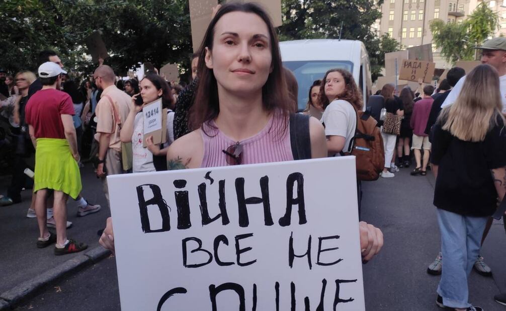Una doctora de 36 años sostiene un cartel con el lema La guerra no puede ser una excusa para todo este miércoles, durante una manifestación en Kiev (Ucrania). Miles de ucranianos se congregaron en el segundo día de protestas contra la aprobación de una ley cuyos críticos creen que despoja de su independencia a dos organismos clave en la lucha contra la corrupción, al someterlos al control del Estado. 
Foto: EFE