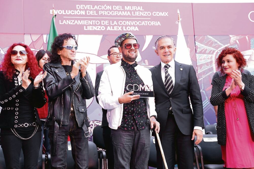 El jefe de Gobierno, Miguel Ángel Mancera —en compañía de los rockeros Chela y Álex Lora— encabezó la presentación del noveno mural realizado por artistas urbanos en el exterior del edificio Juana de Arco en la Plaza Tlaxcoaque. (GOBIERNO DE LA CDMX)