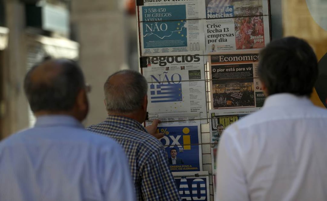 Griegos leen los titulares de los diarios que reportan el resultado del referéndum. Foto: AP