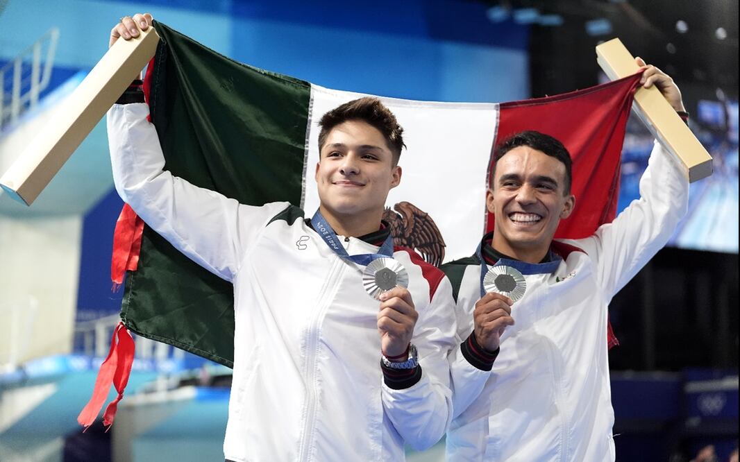 Juan Celaya y Osmar Olvera celebran en el podio tras ganar medalla de plata en el trampolín sincronizado de tres metros en los Juegos Olímpicos de París 2024. Foto: AP