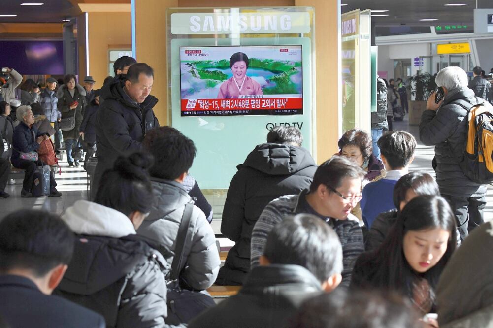 Surcoreanos escuchaban esta mañana en Seúl las noticias sobre el lanzamiento de un misil intercontinental por parte de Norcorea (JUNG YEON-JE. AFP)