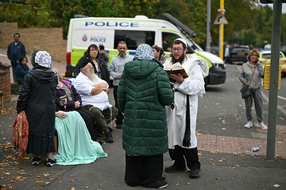 Integrantes de la comunidad judía local se encuentran en la calle frente a la sinagoga de la Congregación Hebrea de Heaton Park en Crumpsall, al norte de Manchester, el 2 de octubre de 2025, tras un ataque en la sinagoga. Foto: AFP