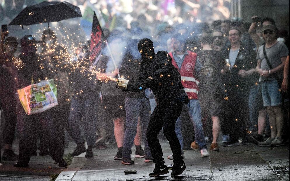 Un manifestante es rociado con agua mientras lanza fuegos artificiales a la policía antidisturbios durante una manifestación por el Día Internacional del Trabajo en la ciudad francesa de Nantes, el jueves 1 de mayo de 2025. Foto: AFP