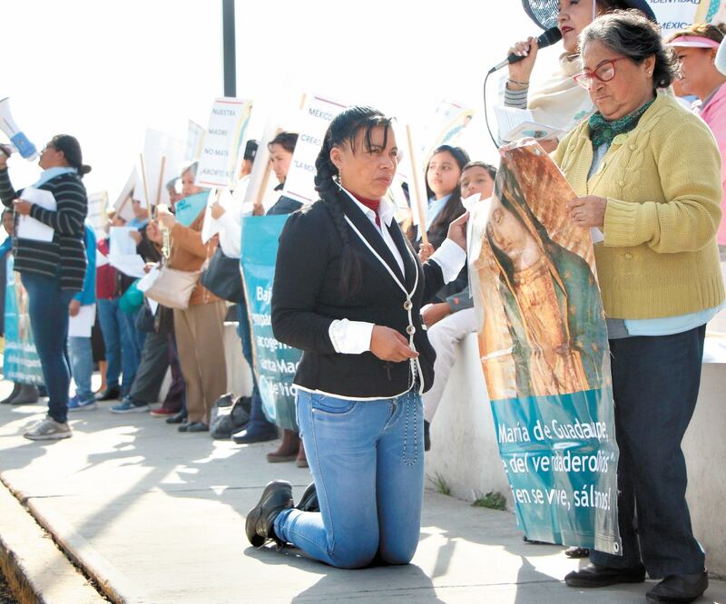 Frente al Congreso un grupo de católicas opositoras al aborto, hincadas con rosario en mano y estandartes de la Virgen de Guadalupe, pedían un milagro. DAVID MARTÍNEZ PELCASTRE. EFE