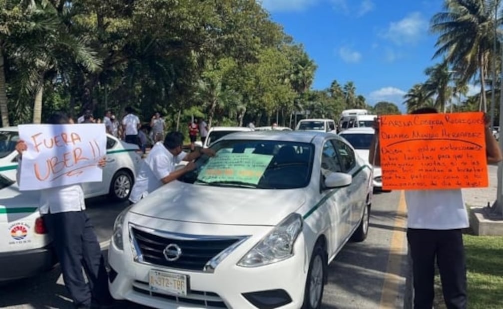 En pleito con Uber, taxistas de Cancún bloquean aeropuerto; policías dan "ride" a turistas