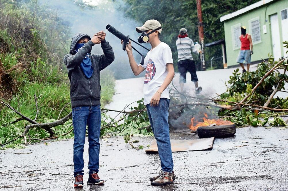 Manifestantes se preparan para enfrentarse a las fuerzas de seguridad antimotines, durante una nueva jornada de protestas ayer, en Palmira (CARLOS EDUARDO RAMÍREZ. REUTERS)