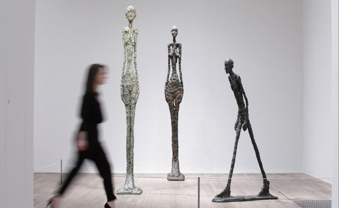 Una mujer pasa junto a varias piezas del artista suizo Alberto Giacometti durante la presentación de la muestra "Giacometti" en la Tate Modern de Londres. (FOTO: EFE)