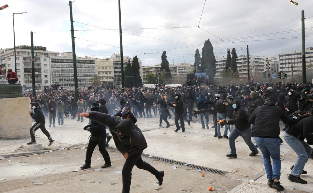 Los manifestantes lanzan cócteles molotov y piedras contra agentes de la policía antidisturbios durante enfrentamientos frente al Parlamento, al margen de una manifestación y una huelga nacional de 24 horas que conmemora el segundo aniversario del accidente del tren de Tempi, en la céntrica plaza Syntagma, en Atenas, Grecia, el 28 de febrero de 2025. Foto: EFE