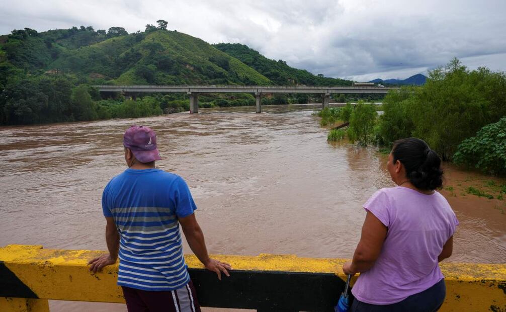 Personas paradas en un puente para observar el desbordamiento del río Ulúa después de la tormenta tropical Sara, en Potrerillos, Honduras, el domingo 17 de noviembre de 2024. Foto: AP