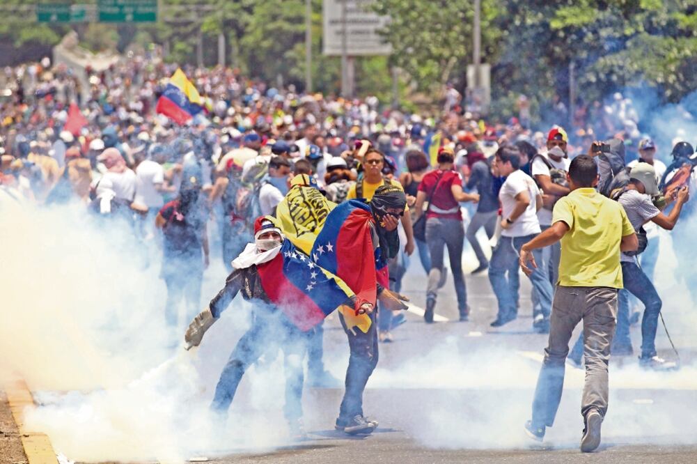 Manifestantes se enfrentaron ayer a elementos de la Policía Nacional Bolivariana durante una protesta en Caracas contra el gobierno del presidente Nicolás Maduro y por el “autogolpe de Estado” en ese país. (ARIANA CUBILLOS. AP)
