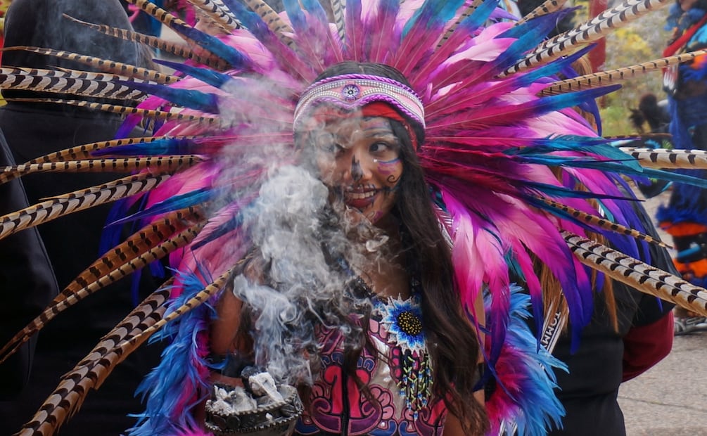 Miembro de grupo de danza azteca sostiene incienso durante una conmemoración del Día de Muertos en una escuela de Minneapolis el sábado 1 de noviembre de 2025. Foto: AP /Giovanna Dell'Orto