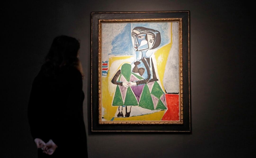Una trabajadora de Christie's posa junto a la pintura de Pablo Picasso de 1954 "Femme accroupie (Jacqueline)", un retrato de su última gran musa y segunda esposa Jaqueline Roque. Foto: AP / Matt Dunham
