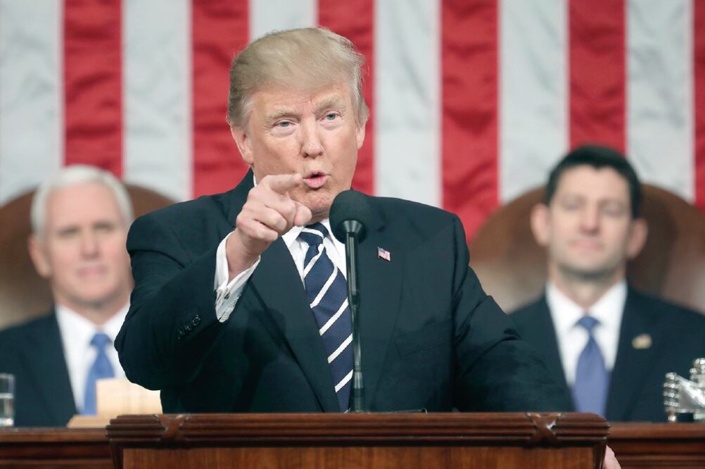 El presidente Donald Trump, ayer durante su discurso en el Congreso de Estados Unidos, en Washington. Atrás, el vicepresidente Mike Pence (izq.) y el presi de nte de la Cámara de Representantes, el republicano Paul Ryan, lo escuchan (JIM LO SCALZO. AP)