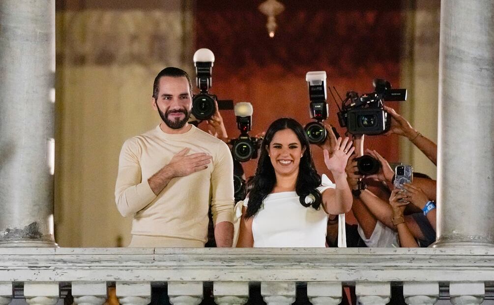 El presidente de El Salvador, Nayib Bukele, acompañado por su esposa Gabriela Rodríguez, saluda a sus seguidores desde el balcón del palacio presidencial en San Salvador, después del cierre de las urnas para las elecciones generales. Foto: AP