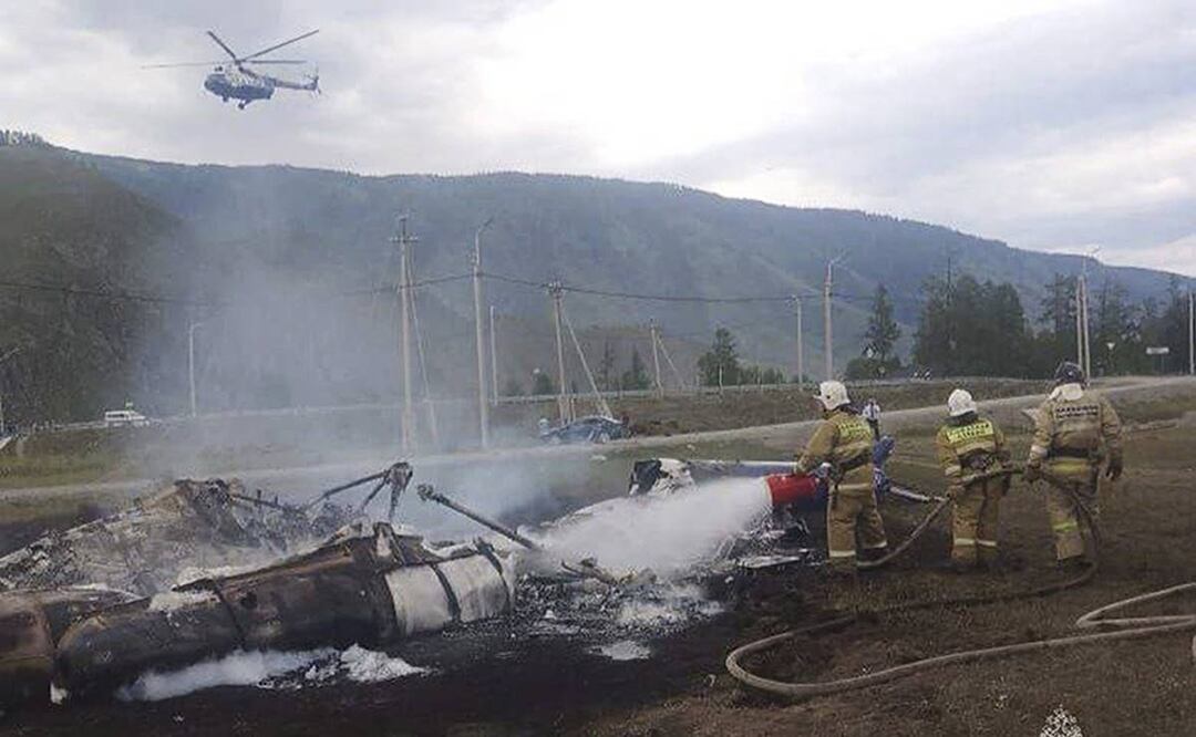 Bomberos apagan un helicóptero Mi-8 después del accidente cerca de la aldea de Tyungur, República de Altai, en el sur de Siberia. Foto: AP