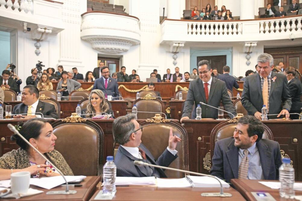 Los perredistas Leonel Luna , presidente de la Comisión de Gobierno, y Raúl Flores, vicecoordinador de la bancada del sol azteca, dialogan en la sesión de ayer con los diputados de Morena César Cravioto y Alfonso Suárez (VALENTE ROSAS. EL UNIVERSAL)