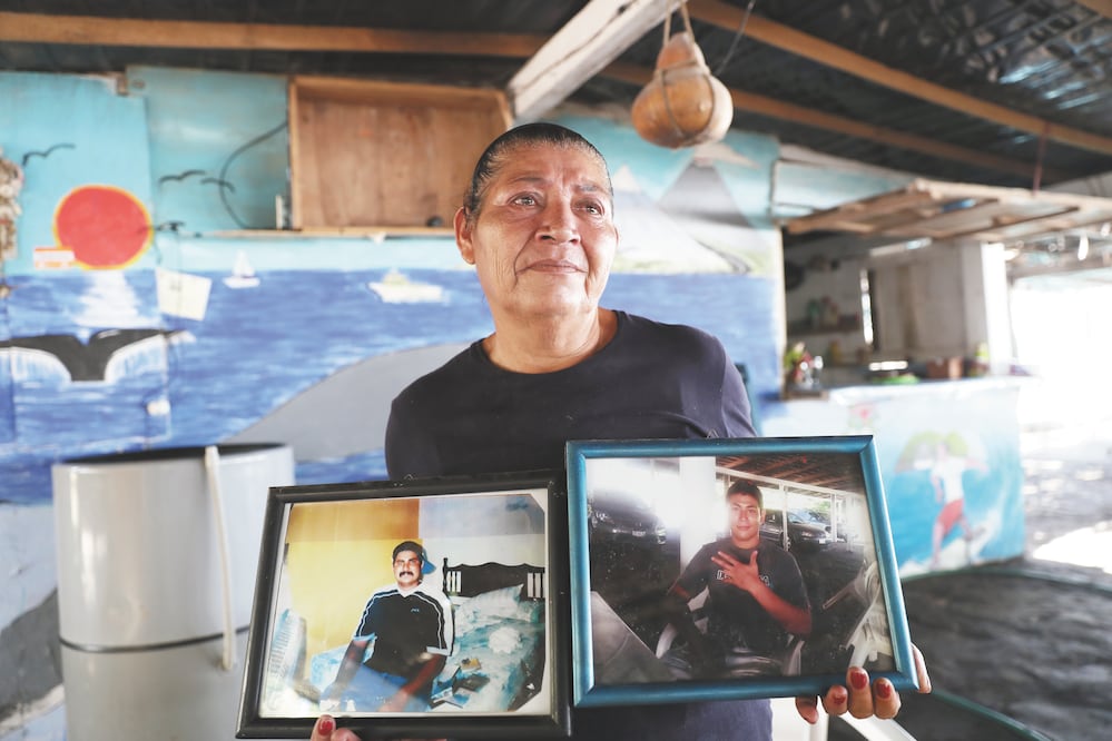Del lado derecho, la mujer carga la foto de su hijo mayor, Mario, quien está desaparecido; del lado izquierdo está Chelino, quien fue asesinado. Foto: VALENTE ROSAS