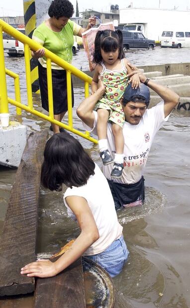 Habitantes surcan una inundación por aguas negras en Valle de Chalco, 2003. Foto: Juan Carlos Buenrostro/EL UNIVERSAL.