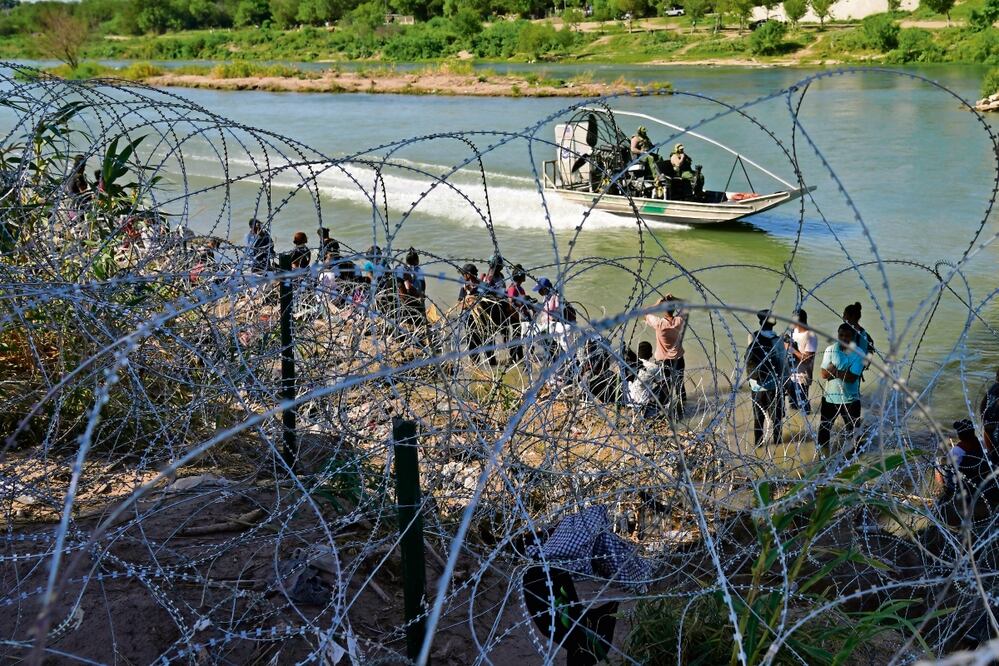 Migrantes que cruzaron desde la frontera mexicana esperan en Eagle Pass, Texas. Foto: AP