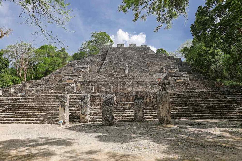 La Gran Pirámide de Calakmul es un ejemplo de cómo las estelas eran parte de la arquitectura maya. En la imagen de fondo, una vista panorámica de la zona arqueológica, ubicada en medio de la selva, donde científicos del Proyecto Bajo el Laberinto han registrado antiguas edificaciones./ Gabriel Pano / El Universal