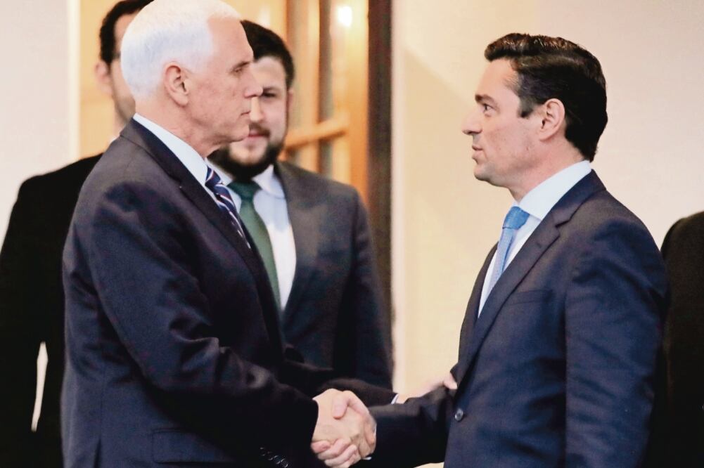 El vicepresidente de EU, Mike Pence (izq.), saluda a Carlos Alfredo Vecchio, encargado de negocios de Venezuela designado por Juan Guaidó. (JIM YOUNG. REUTERS)