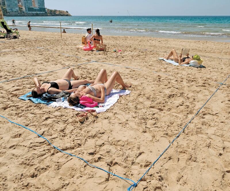 Bañistas en una playa en Benidorm. La imagen más clara de esta nueva normalidad en España es la de las playas con turistas y las carreteras con tráfico. Foto: JOSE JORDAN. AFP