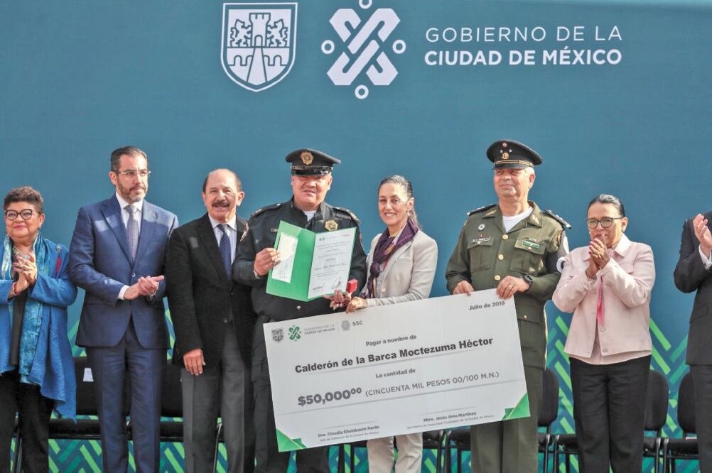 El policía Héctor Moctezuma Calderón de la Barca recibió un premio por 50 mil pesos de manos de la jefa de Gobierno, Claudia Sheinbaum, por ayudar a una mujer a recuperar su bolso con 40 mil pesos. Foto/DIEGO SIMÓN. EL UNIVERSAL