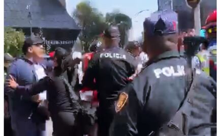 Conato de riña en la Glorieta del Caballito; civiles forcejean con policías durante el desfile de la Revolución