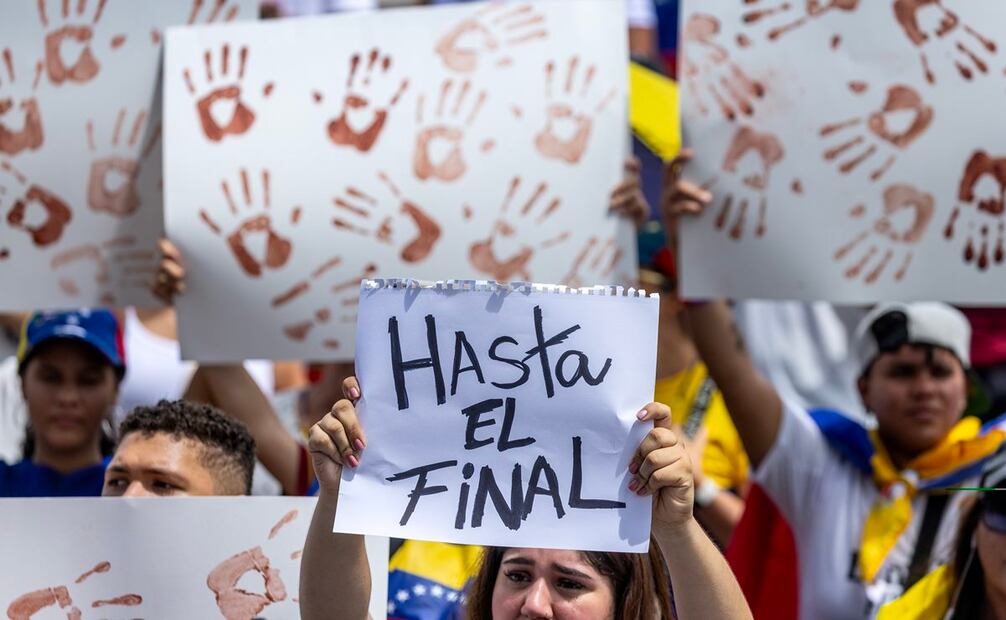 Jóvenes desfilaron con pancartas blancas con huellas de manos color de la sangre. Foto: EFE