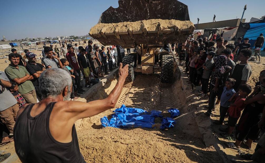 Varias personas asisten al entierro masivo en el cementerio de Jan Yunis, Palestina, de las víctimas de un ataque israelí. Foto: EFE
