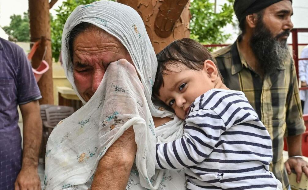 Mujer de la India lloro con su bebé en brazos tras un aumento de las tensiones fronterizas. (09/05/25) Foto: AFP