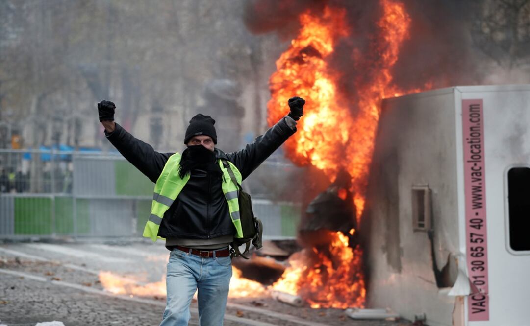 A protester wearing yellow vest, a symbol of a French drivers' protest against higher fuel prices, gestures during riots on the Champs-Elysees in Paris, France - Photo: Benoit Tessier/REUTERS