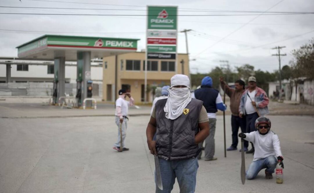 Masked man in front of a Pemex gas station - Photo: AP