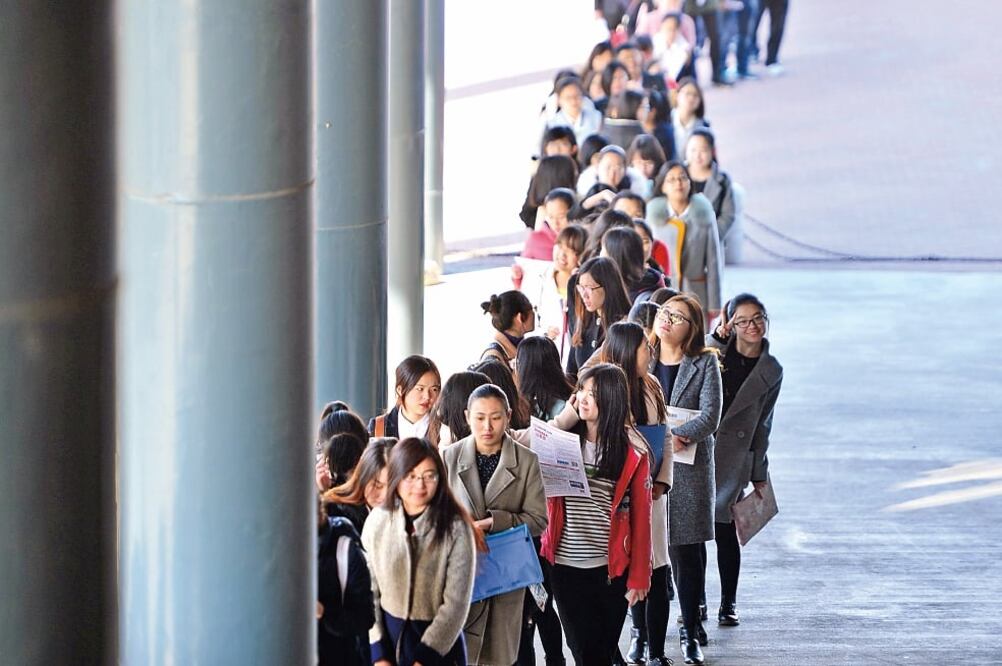 Jóvenes chinas esperaban ayer entrar a una feria de empleo en la Universidad de Tianjin (YOU SIXING. EFE)