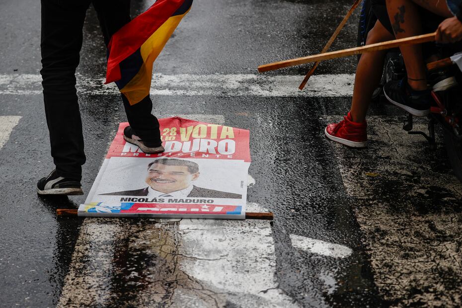 AME6288. CARACAS (VENEZUELA), 29/07/2024.- Una persona pisa un cartel con la imagen del presidente de Venezuela, Nicolás Maduro, durante una protesta por los resultados de las elecciones este lunes, en Caracas (Venezuela). Protestas en Caracas luego de que el Consejo Nacional Electoral (CNE) proclamara a Nicolás Maduro como presidente reelecto de Venezuela, tras los comicios celebrados este 28 de julio. Foto: EFE