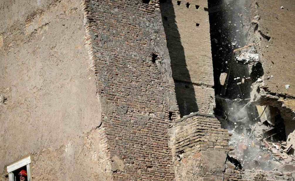 Un bombero gesticula mientras parte de la torre medieval "Torre dei Conti", donde un trabajador aún permanece atrapado, se derrumba por segunda vez cerca del Foro Romano, en el centro histórico de Roma, el 3 de noviembre de 2025. Tres trabajadores que se encontraban dentro fueron evacuados; uno de ellos fue trasladado al hospital en estado crítico, según informó a la AFP un portavoz de los bomberos. Sin embargo, un trabajador permanecía atrapado en el interior, según un funcionario de la alcaldía. Foto: AFP