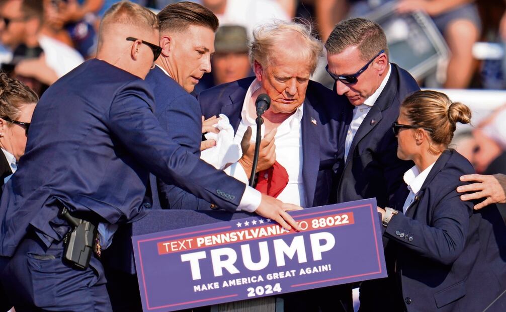 El candidato presidencial republicano, Donald Trump, al recibir ayuda para bajar del escenario en un mitin en Butler, Pennsylvania, tras el atentado en su contra. Foto: Gene J. Puskar | AP
