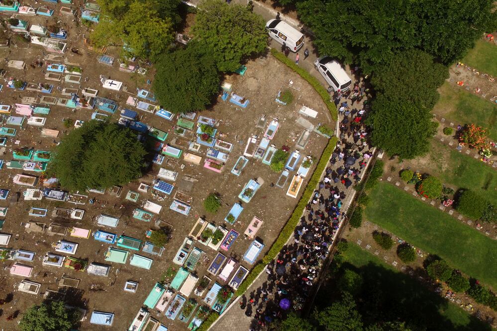 Unas 50 personas llevaban flores y seguían un auto fúnebre hacia el cementerio de La Bermeja (Foto: AP. Interior: EFE)